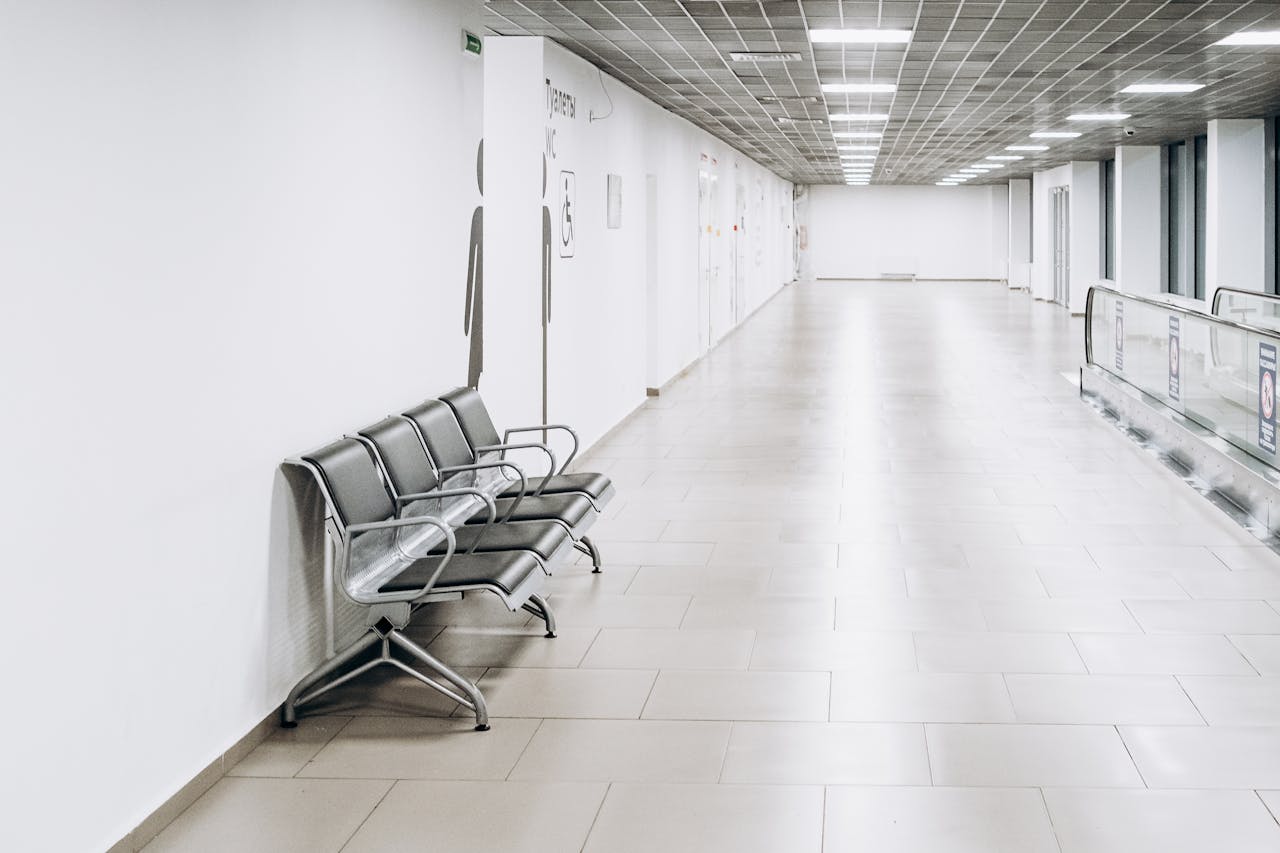 Modern empty large white hall of terminal with luminous bright lamps on ceiling